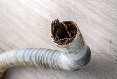 Tıkanmış plastik kanalizasyon borusu yerde yatıyor. Seçici odak.