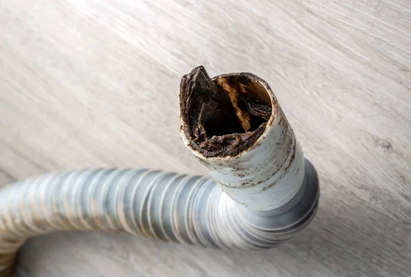 Tıkanmış plastik kanalizasyon borusu yerde yatıyor. Seçici odak.