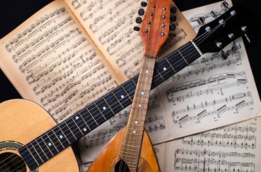 Arka planda eski bulanık nota kitaplarıyla Mandolin ve gitar.  