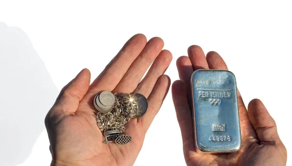 Silver bullion 1 kilo and old silver coins and jewelry in the hands isolated on white. feinsilber is fine silver.