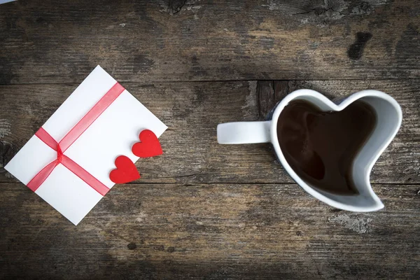 ahşap masa üzerinde bir kalp ve sevgi mektup şeklinde Kupası