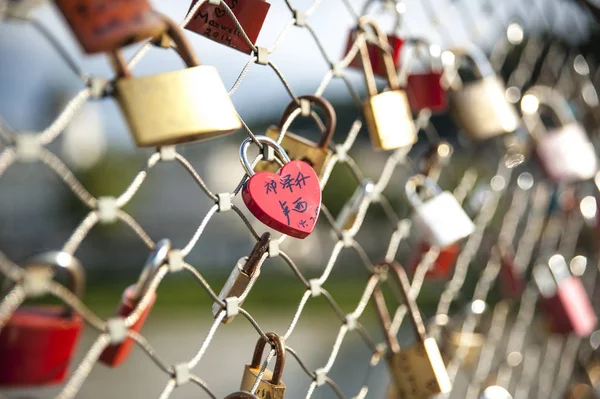 Som ett löfte om kärlek stänga älskare hänglås längs bron — Stockfoto