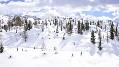 Alplerde kayakçılarla kayak pisti