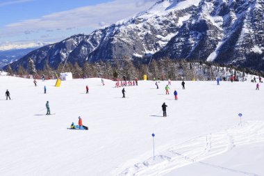 Alplerde kayakçılarla kayak pisti