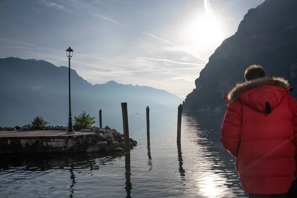 Homem vestido de vermelho admira a vista do Lago de Garda . — Fotografia de Stock