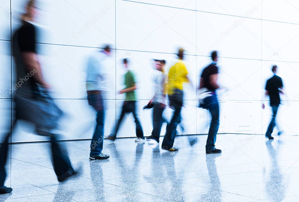 crowd of blurred people walking in a modern hall