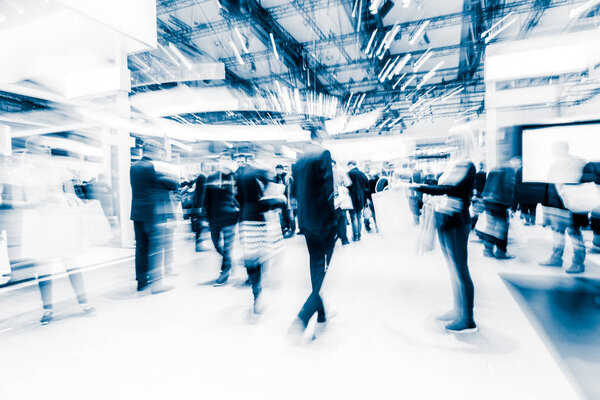 blurred people at a trade fair hall