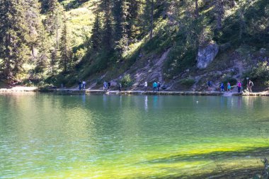 Misurina, İtalya - 23 Ağustos 2016: Güneşli bir günde insanlar Belluno Dolomitlerinin kalbinde gölün etrafında yürür
