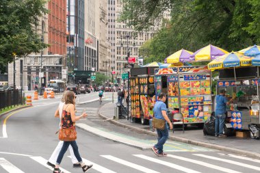 New York City, ABD - 6 Ağustos 2019: Bulutlu bir günde New York 'ta günlük hayat. Burada ünlü sokak yemeği satıcılarının büfelerinin manzarası