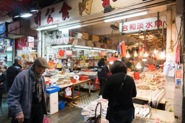 Hong Kong, 24 Mart 2019: Bulutlu bir günde, Hong Kong 'un dar ve kalabalık sokaklarındaki klasik pazarlar arasında insanlar