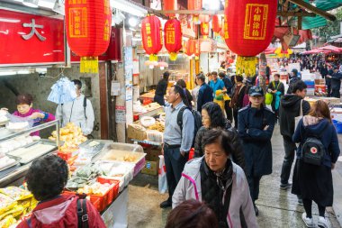 Hong Kong, 24 Mart 2019: Bulutlu bir günde, Hong Kong 'un dar ve kalabalık sokaklarındaki klasik pazarlar arasında insanlar