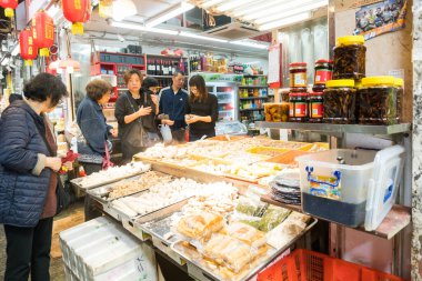 Hong Kong, 24 Mart 2019: Bulutlu bir günde, Hong Kong 'un dar ve kalabalık sokaklarındaki klasik pazarlar arasında insanlar