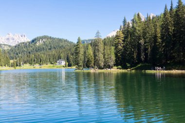 Misurina, İtalya - 23 Ağustos 2016: Güneşli bir günde insanlar Belluno Dolomitlerinin kalbinde gölün etrafında yürür