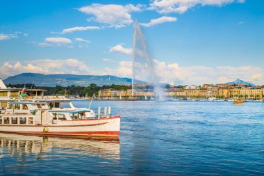 Tarihi şehir Cenevre ünlü Jet d'Eau çeşme ve gün batımında gemiler ile