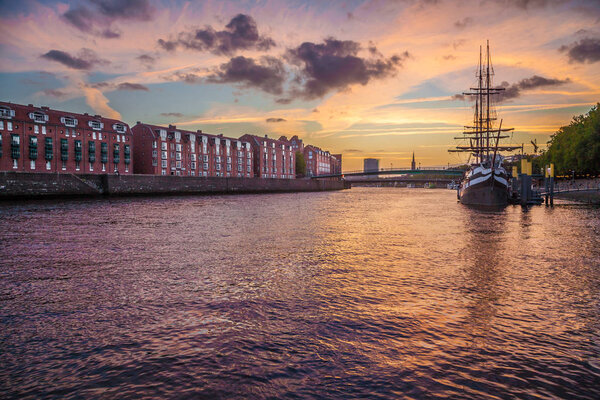 City of Bremen with old sailing ship on Weser river at sunset, Germany