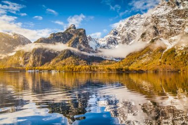 Idyllic autumn scene in the Alps with mountain lake reflection in beautiful morning light clipart