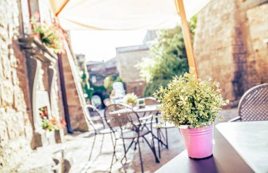 Avrupa 'nın eski bir caddesinde eski tip Instagram tarzı filtre efektli masa ve sandalyeli kafe