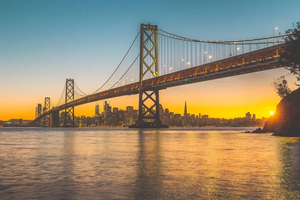 San Francisco panoramę z Oakland Bay Bridge o zachodzie słońca, California, Stany Zjednoczone Ameryki — Zdjęcie stockowe