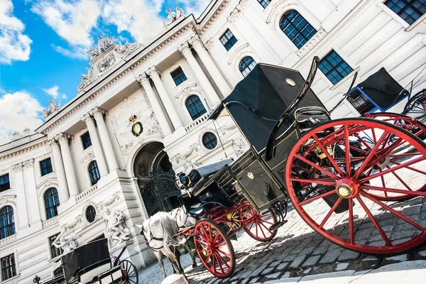 Wide-angle view of famous Hofburg Palace with traditional horse-drawn Fiaker carriages on a sunny day in Vienna, Austria — Stock Photo, Image