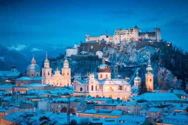 Ünlü Festung Hohensalzburg ve Salzach nehri ile tarihi Salzburg şehrinin klasik manzarası. Kış aylarında güzel bir alacakaranlıkla aydınlanıyor. Salzburger Diyarı, Avusturya.
