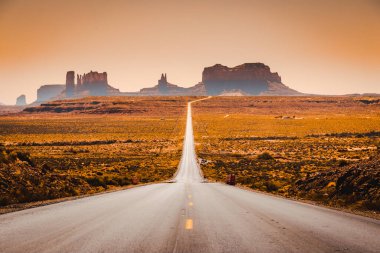 Tarihi ABD Route 163 klasik panorama görünümü yaz aylarında gün batımında güzel altın akşam ışığında ünlü Monument Valley üzerinden çalışan, Utah, Abd