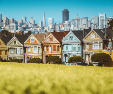 Arkasında San Francisco 'nun silueti olan Alamo Meydanı' ndaki renkli Viktorya dönemi evlerinden oluşan ünlü Boyalı Kadınlar 'ın klasik kartpostal görüntüsü.