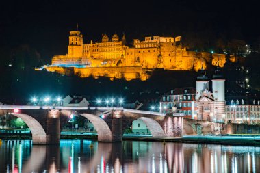 Eski Heidelberg şehrinin panoramik manzarası gece güzel Neckar nehrine yansıyor, Baden-Wuerttemberg, Almanya
