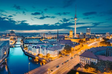 Berlin 'in klasik gökyüzü manzarası ünlü TV kulesi ve gün batımında güzel bir altın akşam ışığı altında Spree, Berlin Mitte, Almanya' nın merkezi.