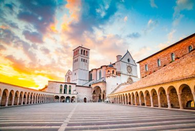 Famous Basilica of St. Francis of Assisi (Basilica Papale di San Francesco) with Lower Plaza at sunset in Assisi, Umbria, Italy clipart