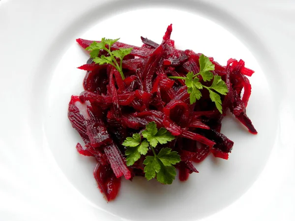 beet salad with parsley on a white plate