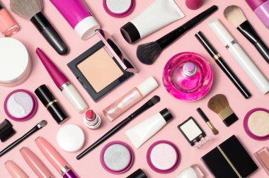 Makyaj kozmetik, fırçalar, kapatıcı ve diğer temel pembe bir arka plan üzerinde kümesi