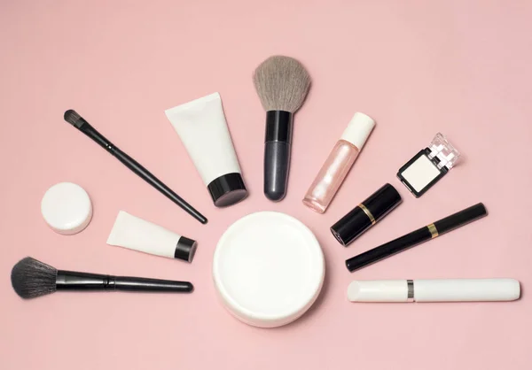 Zestaw kosmetyków do makijażu, pędzle, korektor i inne podstawowe na różowym tle — Zdjęcie stockowe
