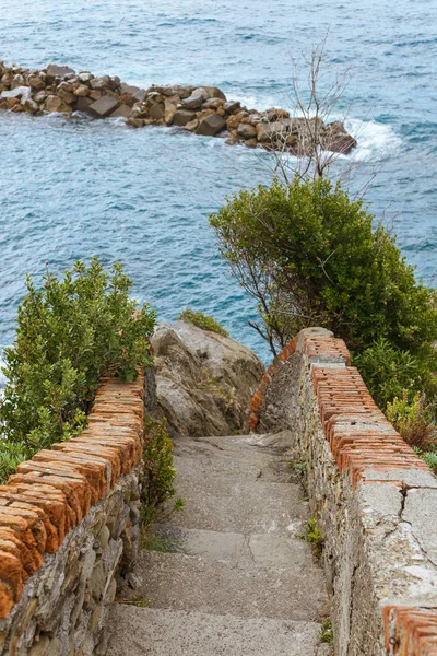 Escaleras viejas y hermoso paisaje marino con piedras en Riomaggiore, Italia - foto de stock