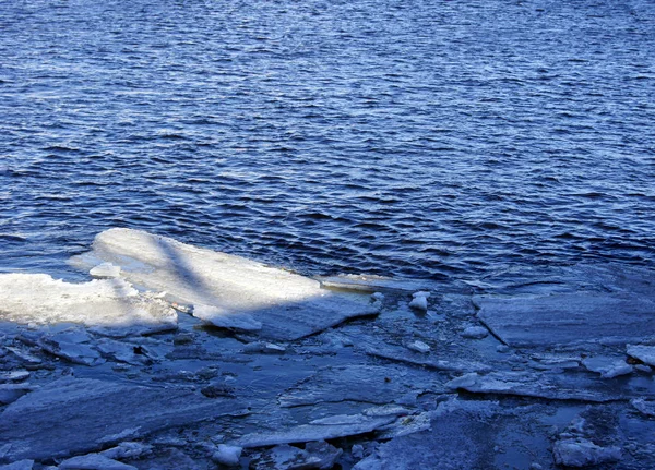 Flotteurs de glace brisés le long de la rivière — Photo