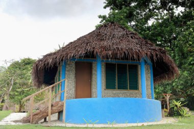 Blue thatched bungalow in Lonnoc Beach. Espiritu Santo island-Vanuatu. 7005 clipart