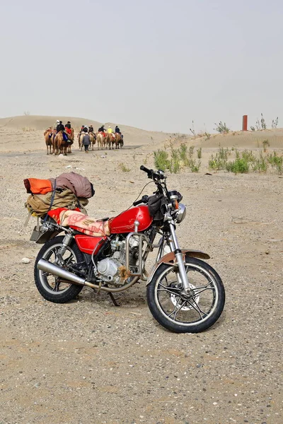 Moderní a tradiční dopravní motocykl a velbloudi. Rawak Stupa oblast-Talamakan poušť-Čína-0015 — Stock fotografie