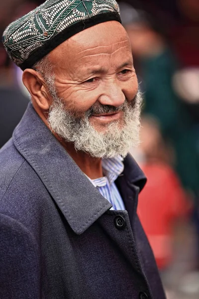 中国和田 2017年10月3日 维吾尔族土尔族留胡子的老人头戴绿白绣花头巾 在该市的集市上展示自己的民族特征 新疆地区 — 图库照片