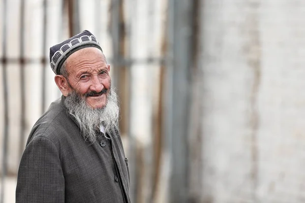 中国和田 2017年10月3日 维吾尔族是一个突厥民族 主要生活在新疆维吾尔自治区 在星期日街市的后区 满脸笑容 留着长长的灰胡子的老人走在街上 — 图库照片