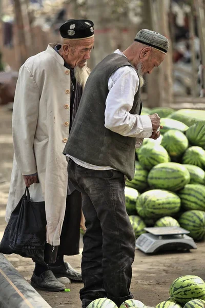 中国和田 2017年10月4日 维吾尔族是突厥人 主要居住在新疆维吾尔自治区 头脑清醒的白胡子老人来到牲畜市场上的一个西瓜摊 — 图库照片