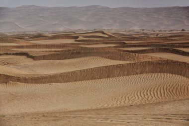 Hareket eden kum tepecikleri Taklamakan Çölü 'nün yüzeyini kaplayarak bu eoliyan topoğrafi formların zincirlerini oluşturur. Bazıları 300 metreye kadar ulaşır. Yutian Keriya ilçesi-Xinjiang Uygur bölgesi-Çin