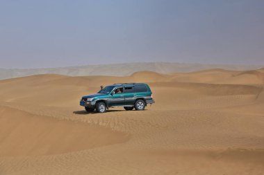 Keriya İlçesi, Çin-5 Ekim 2017: Turizm hizmetleri için yeşil SUV, Taklamakan çölünün tehlikeli kumsallarından geçerken, aynı zamanda off-road 'un popüler bir türüdür..