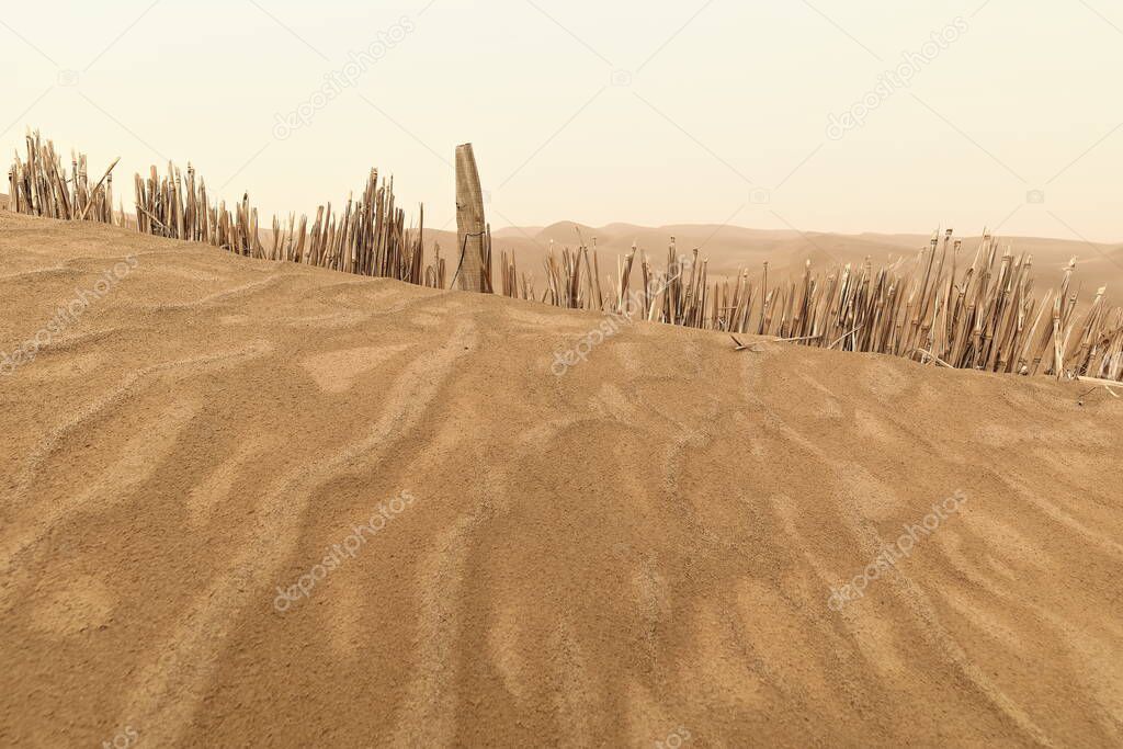 Reed checkerboard control barriers protect the Tarim Desert Highway crossing the Taklamakan Desert for nearly 550 kms.from the shifting sand dunes. Hotan prefecture-Xinjiang Uyghur region-China.