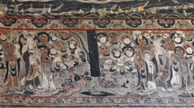 Mogao mağaralarının bulunduğu kayalıkların dış duvarlarının boyanmış kalıntıları yerel kumtaşına kazınmış ve 4. yüzyıla kadar uzanan Budist betimlemelerini tasvir ediyor. Dunhuang-Gansu-Çin.