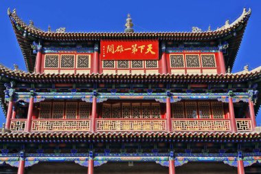 Guanghua Lou-Aydınlanma Kapısı 'nın üç katlı doğu kapısı üzerinde kırmızı plakalı Jiayuguan toprak duvarında Tian Xia Di Yi Xiong Guan-First ve Cennetin En Büyük Geçidi yazıyor. Gansu-Çin