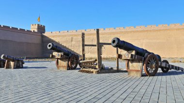 İç avluda eski bronz toplar var. Direkli toprak ve tuğlalı iç batı duvarı ve iç Jiayu Geçidi Kalesi 'nin SW köşesinde bayrak taşıyan gözetleme kulesi. Jiayuguan şehri-Gansu bölgesi-Çin.