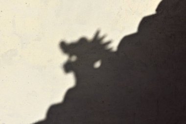 Game of light and shadow: xie shan roof shade casting a hornless dragon head silhouette on the rammed loess-earthen wall of the inner fortress. Jiayu Guan Pass-Jiayuguan city-Gansu province-China. clipart