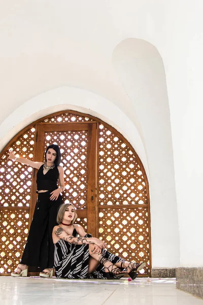 Hermosas Chicas Elegantes Mirando Cámara Posando Cerca Puertas Madera Decorativas — Foto de Stock