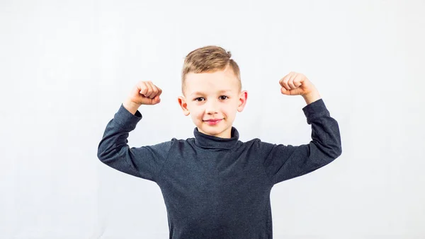 Sevimli küçük çocuk güç gösteriyor. Beyaz bir arka planda. Boşluğu kopyala