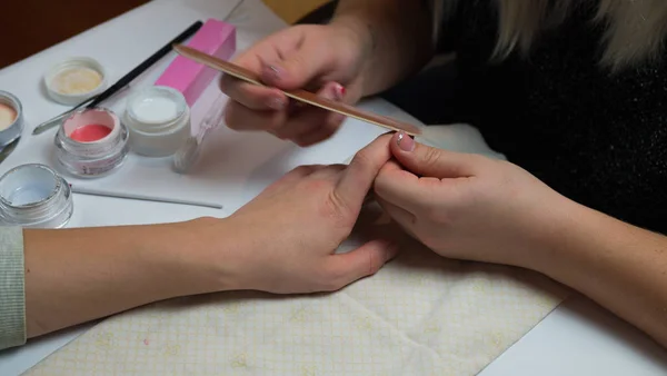 Manicure. Master make nail extension. hands closeup