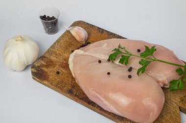 Çiğ tavuk göğsü ve baharatlar ahşap kesim tahtasının üzerinde, yakın görüş.